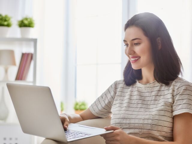 Happy Lady on Computer doing her own Taxes