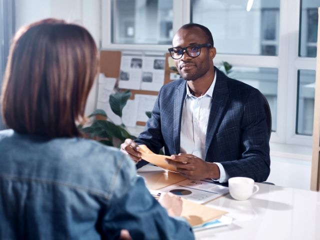 Tax Season Preparing choose a good tax preparer. A top tax tip with accountant going over taxes with client.