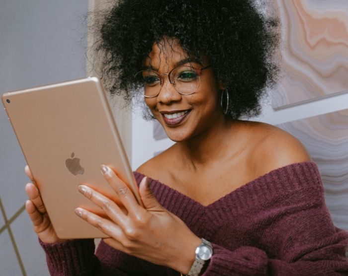 Lady on IPad reading bank statement of saving $3000 in 6 months.