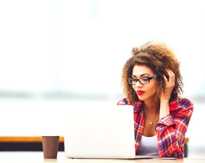 Woman on laptop reading about money saving tips for Millennials