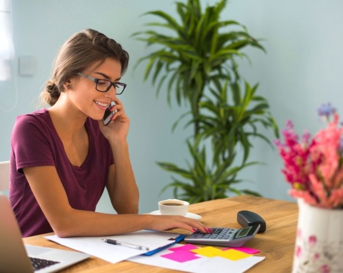 Woman at table working on paying off debt quickly.