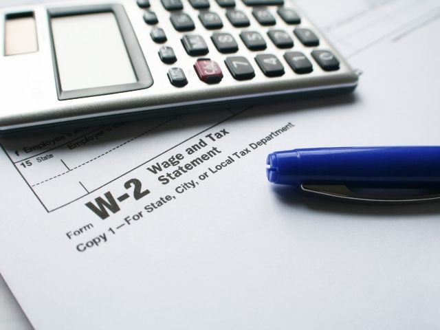 How to calculate AGI from W2 form with calculator next to blue pen