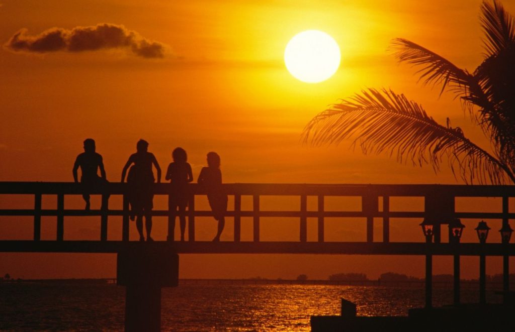 Florida sunset at beach with people on pier