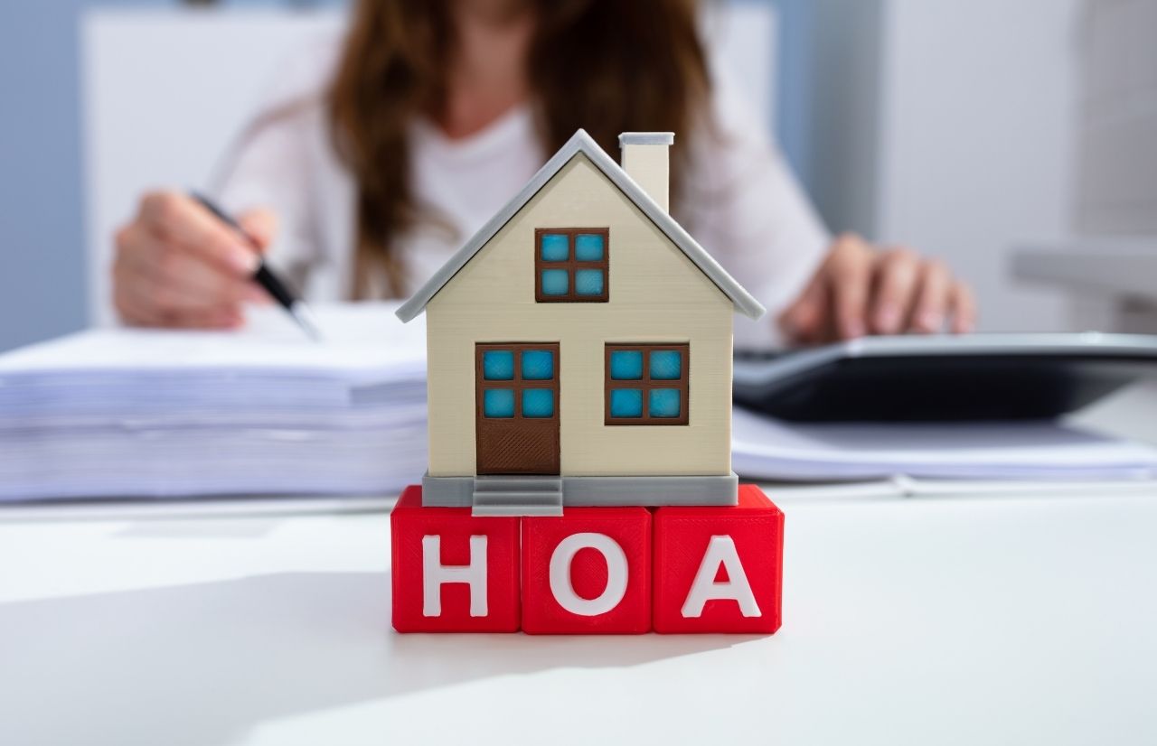 Are HOA Fees tax deductible with toy house on top of red letters HOA