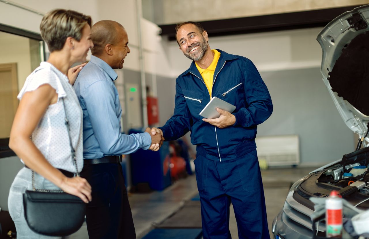 Mechanic explaining the difference between oe vs oem to customer in his car garage.