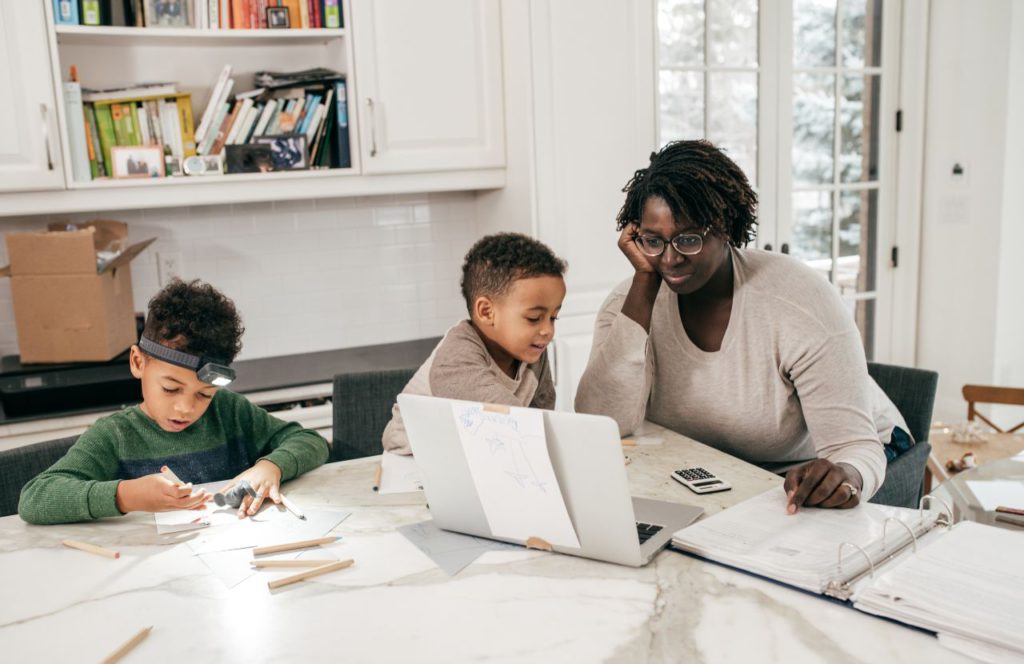 woman with kids in the kitchen reading is homeschooling tax deductible