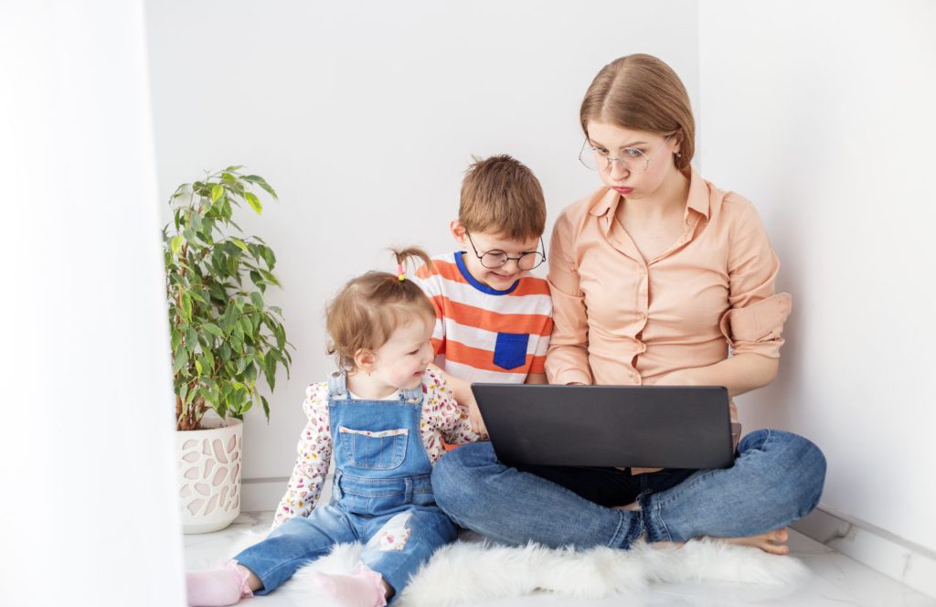 a single side hustling mom with her kids on her computer figuring out financial challenges