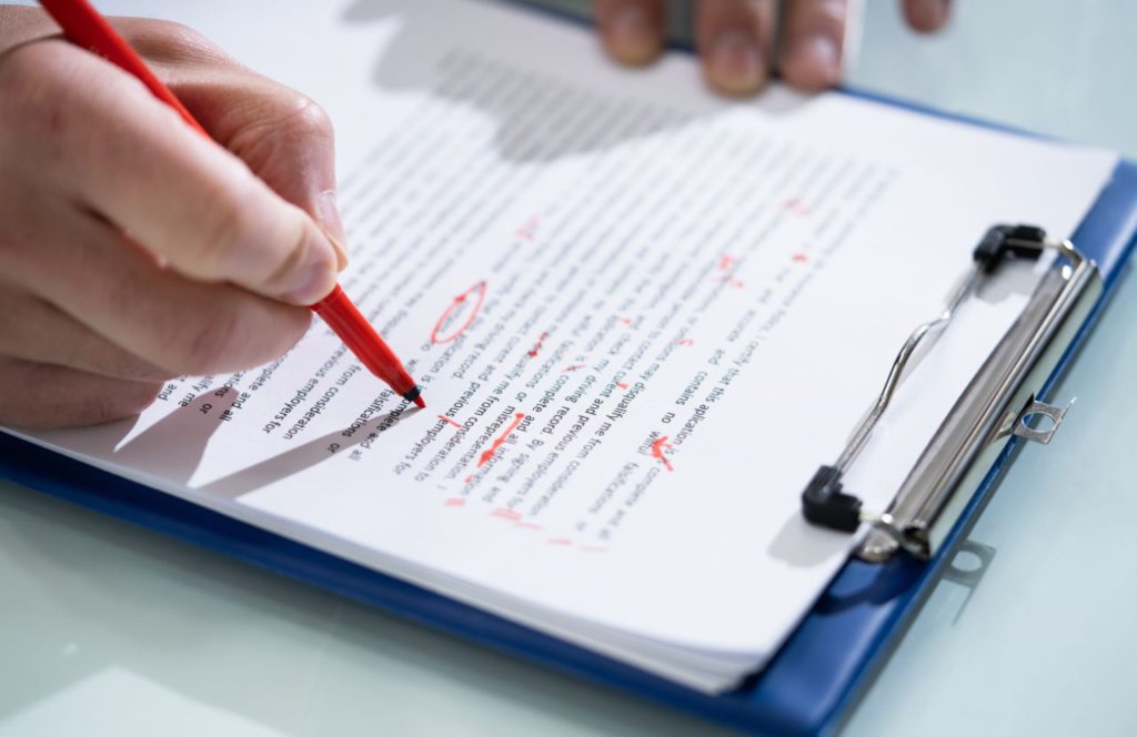 a hand editing a document on a clipboard detailing information on tax resolution