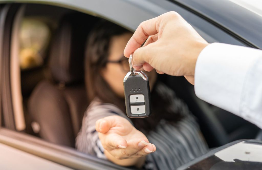 man handing a woman car keys after leasing new car and may be able to deduct the sales tax paid on the lease payments