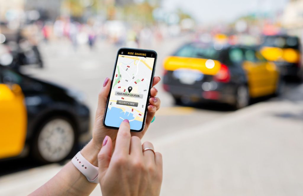 woman hands looking at phone man requesting ride share from application with track her miles so she can get reimbursements for taxable mileage