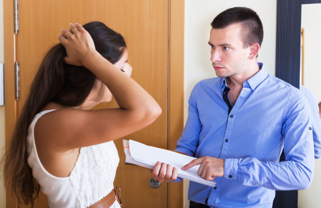 woman in shock with hand over her head while man explain a document of everything she know to deal with tax resolution
