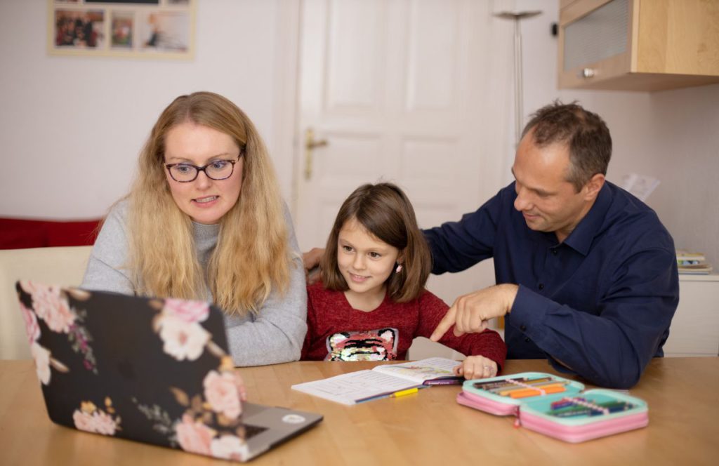 man woman girl at kitchen table on laptop doing school work and searching online the term is homeschooling tax deductible