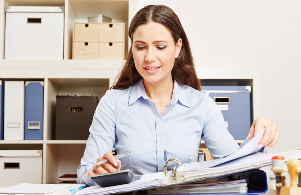 woman in office using calculator to calculate tax refund