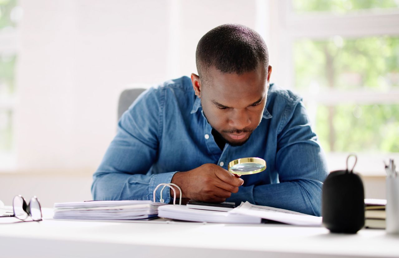 man with magnifying glass looking for tax credits